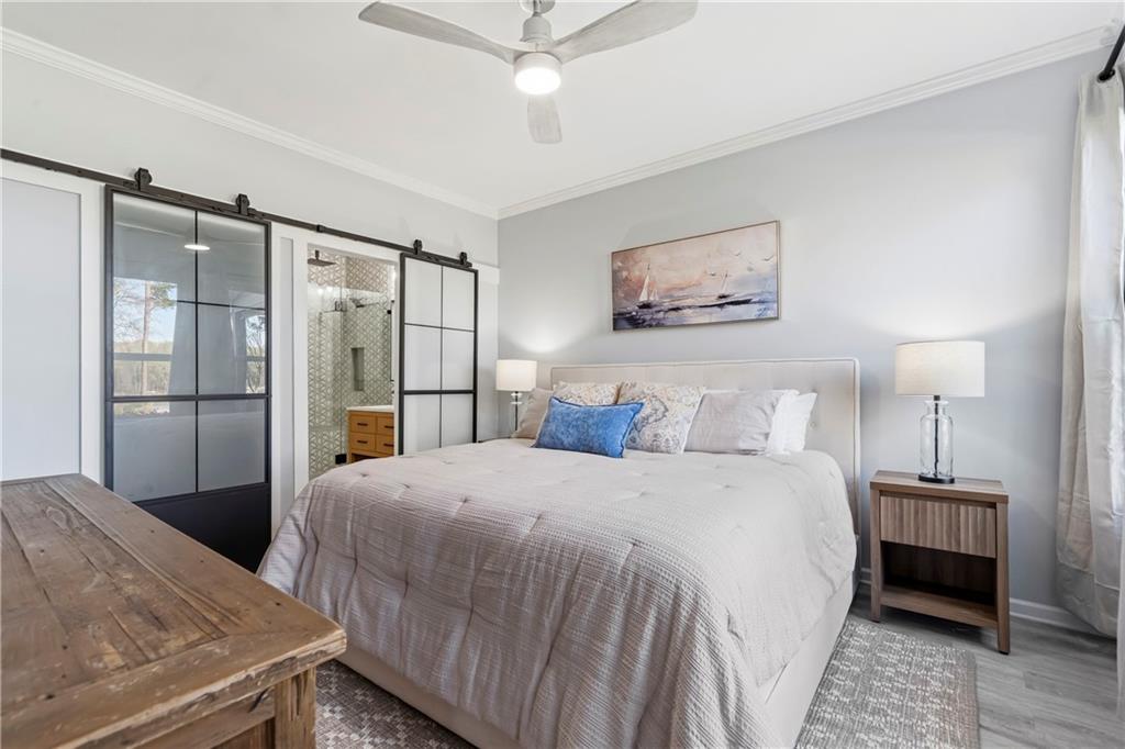 549 Old Phoenix Road Northeast, Unit 104 Eatonton, GA 31024 - Photo 18 of 48 a bedroom with a bed and a chandelier