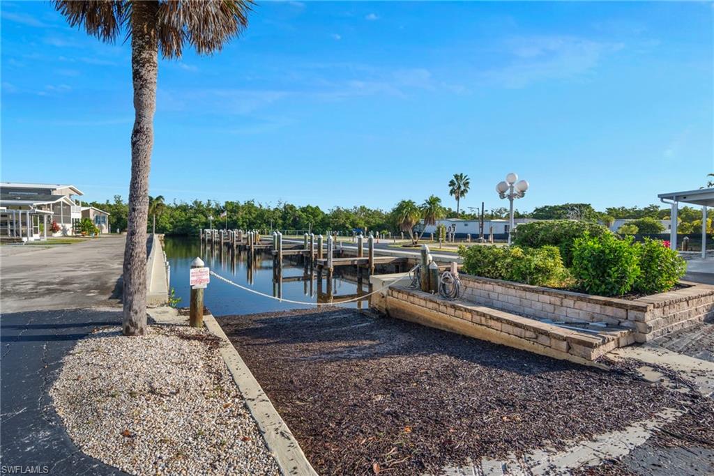 777 Walkerbilt Road, Unit 34 Naples, FL 34110 - Photo 23 of 23 Dock with a boat ramp and a water view
