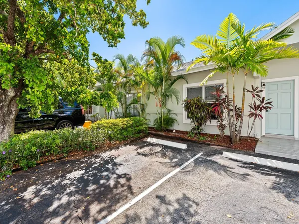 a front view of a house with a yard and potted plants