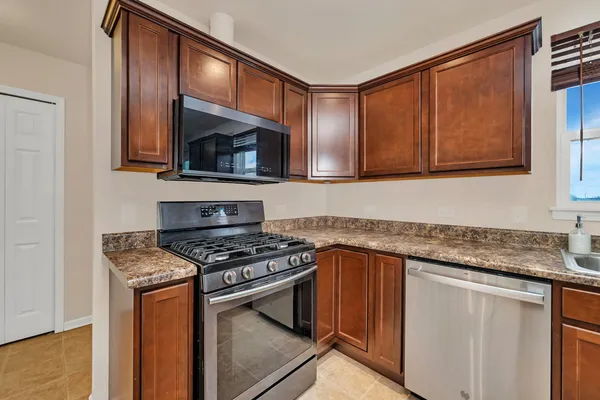 a kitchen with granite countertop cabinets stainless steel appliances and a sink