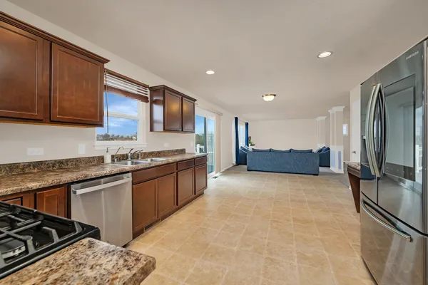 a kitchen with stainless steel appliances granite countertop a sink stove and refrigerator