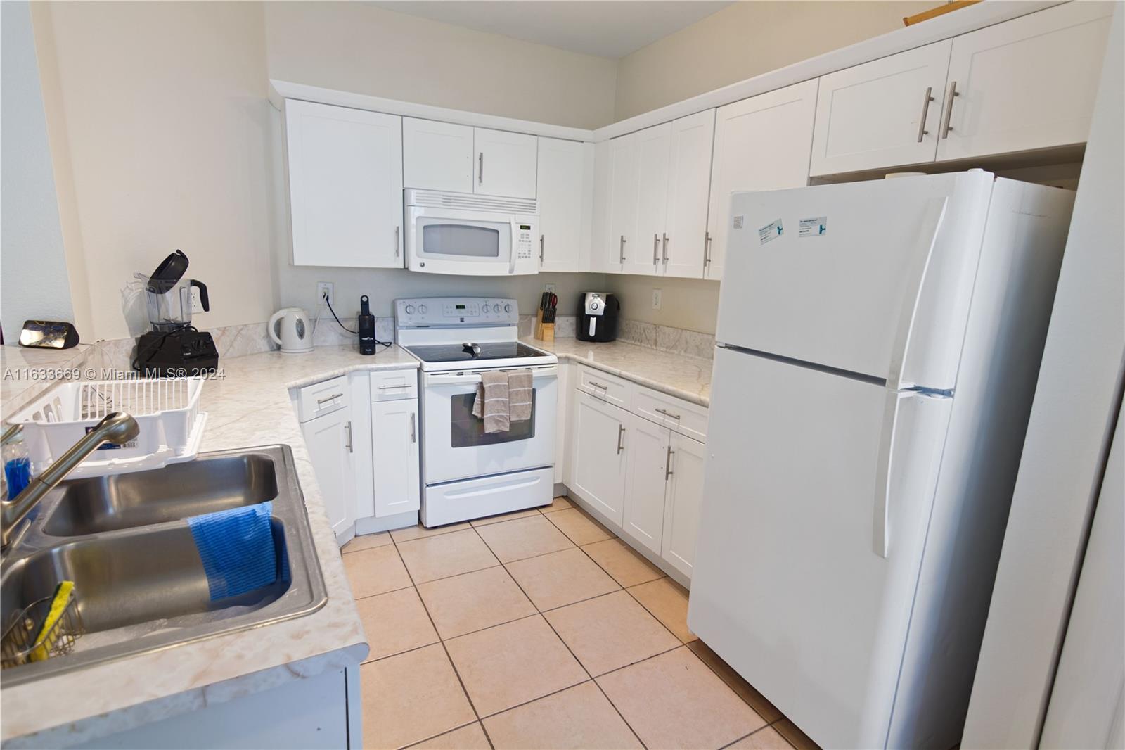 11051 Southwest 246th Street Homestead, FL 33032 - Photo 11 of 30 a kitchen with white cabinets and white appliances