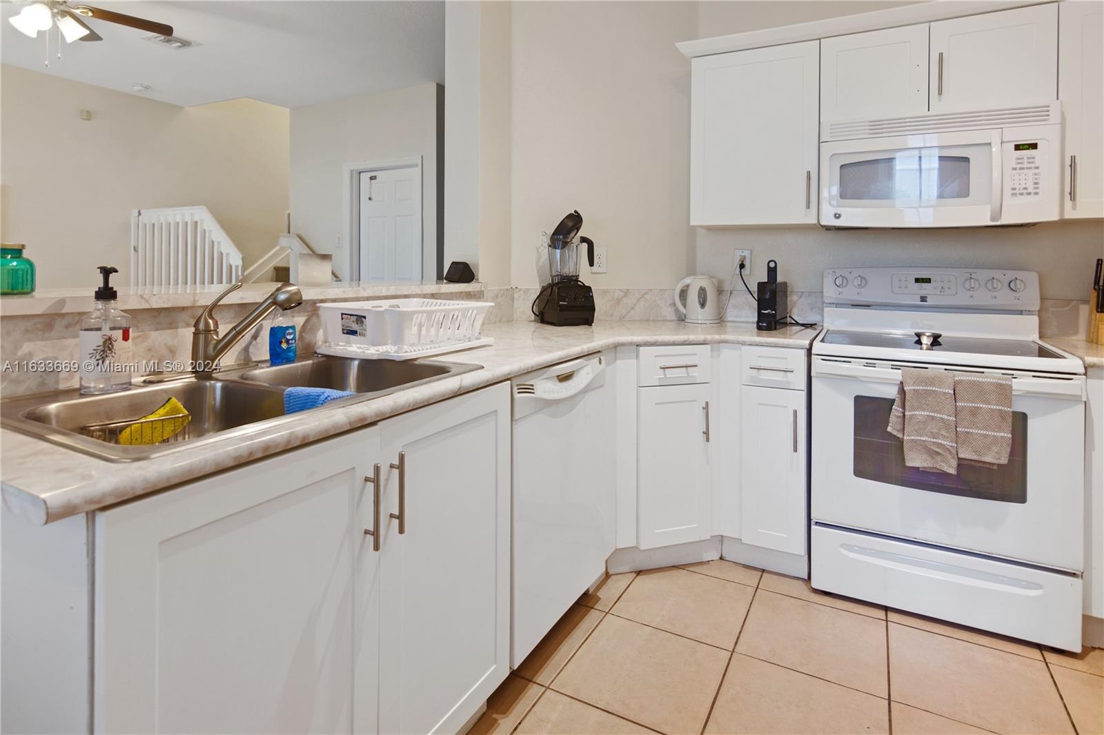 11051 Southwest 246th Street Homestead, FL 33032 - Photo 10 of 30 a kitchen with white cabinets and white appliances