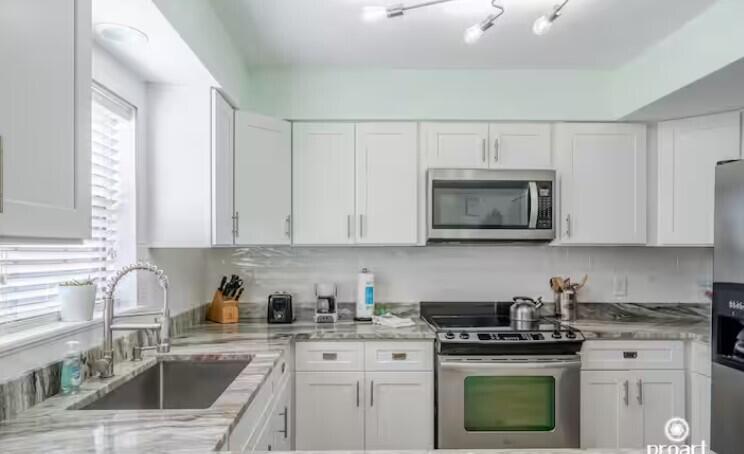 186 Durango Road Destin, FL 32541 - Photo 4 of 29 a kitchen with white cabinets and appliances