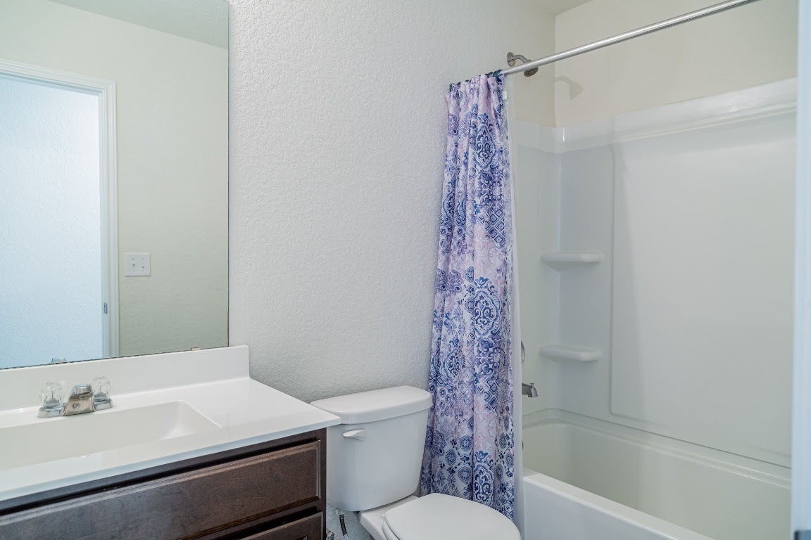 15225 Harkness Pass Austin, TX 78725 - Photo 17 of 23 a bathroom with a shower curtain and a sink