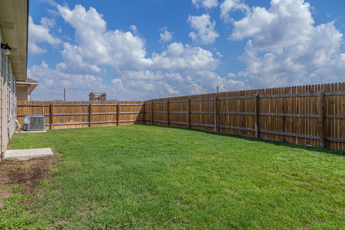 15225 Harkness Pass Austin, TX 78725 - Photo 21 of 23 a view of a yard with a wooden fence