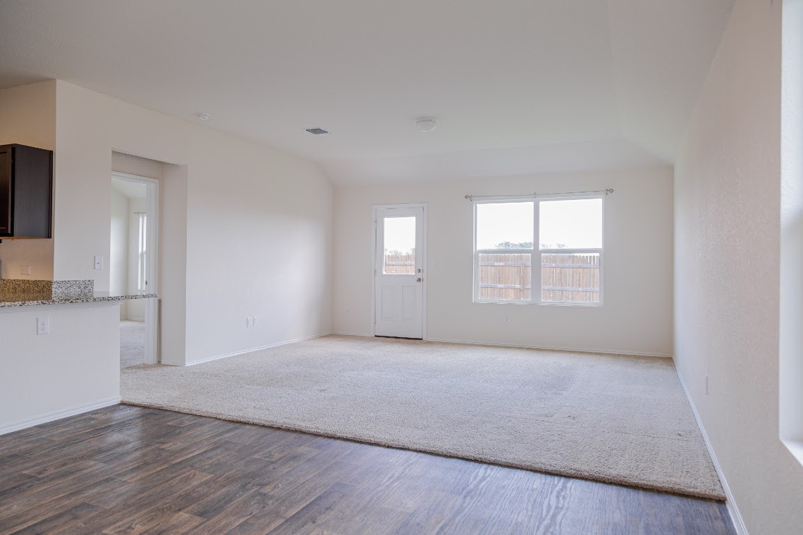 15225 Harkness Pass Austin, TX 78725 - Photo 5 of 23 an empty room with wooden floor and windows