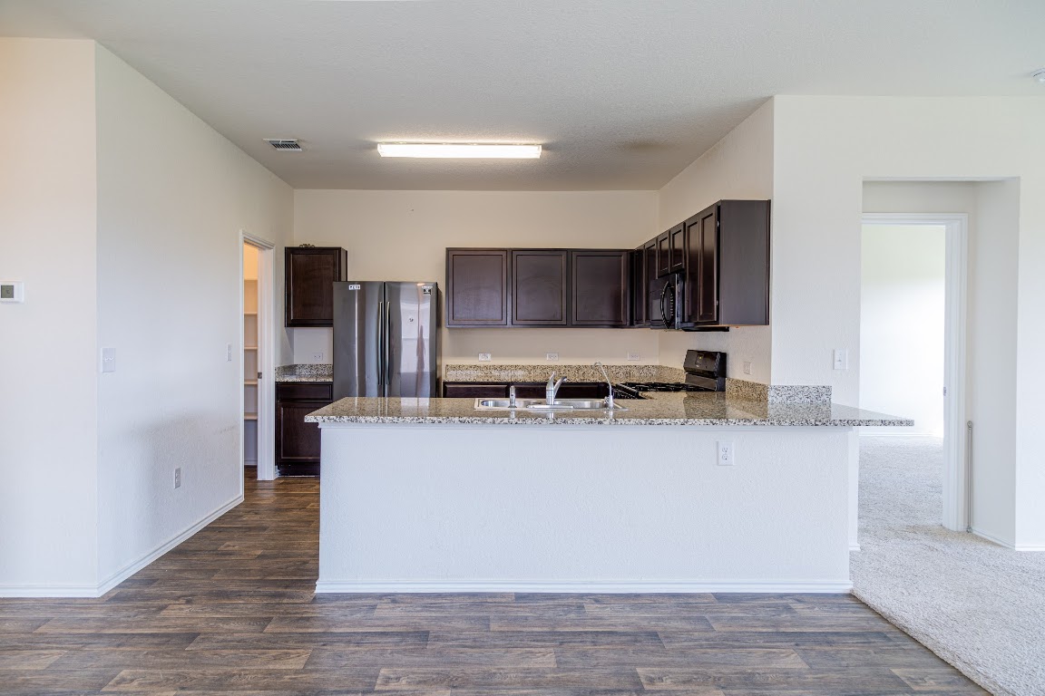 15225 Harkness Pass Austin, TX 78725 - Photo 8 of 23 a kitchen with stainless steel appliances granite countertop a table and a refrigerator