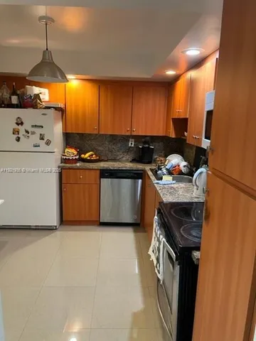 a kitchen with granite countertop a sink stove and cabinets