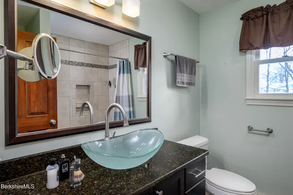 a bathroom with a granite countertop sink and a mirror