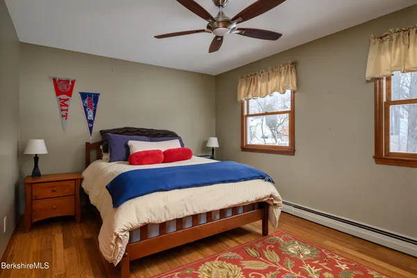 a bedroom with a bed next to a window and a lamp