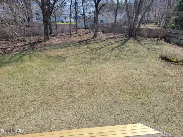 a view of a backyard with wooden fence