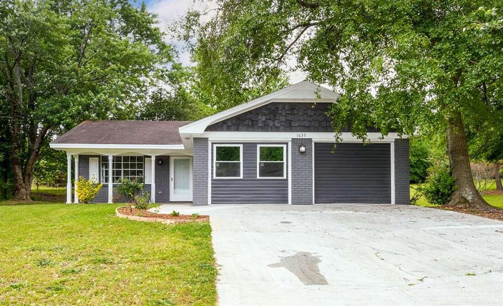 a front view of a house with a garden and yard