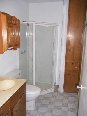 a bathroom with a granite countertop sink toilet and shower