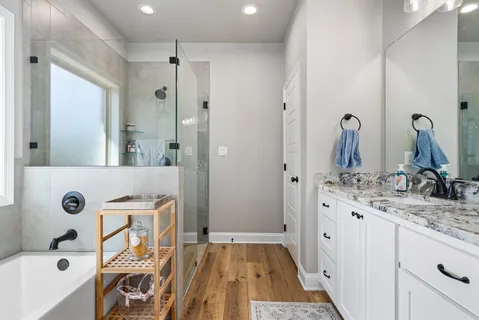 a bathroom with a tub sink and mirror