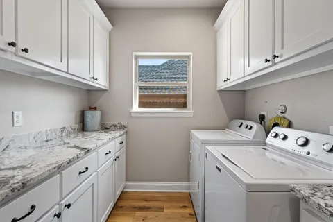 a utility room with cabinets washer and dryer
