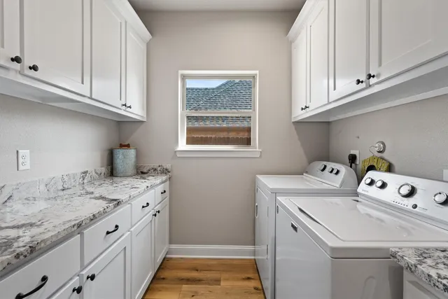 a utility room with cabinets washer and dryer