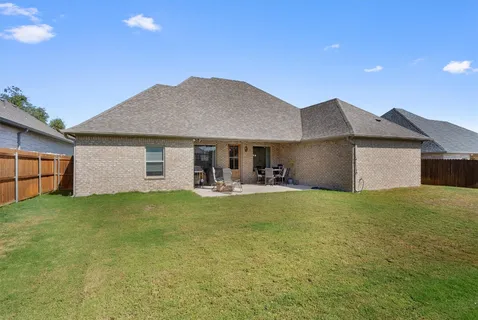 a front view of house with yard barbeque and wooden fence