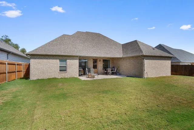 a front view of house with yard barbeque and wooden fence