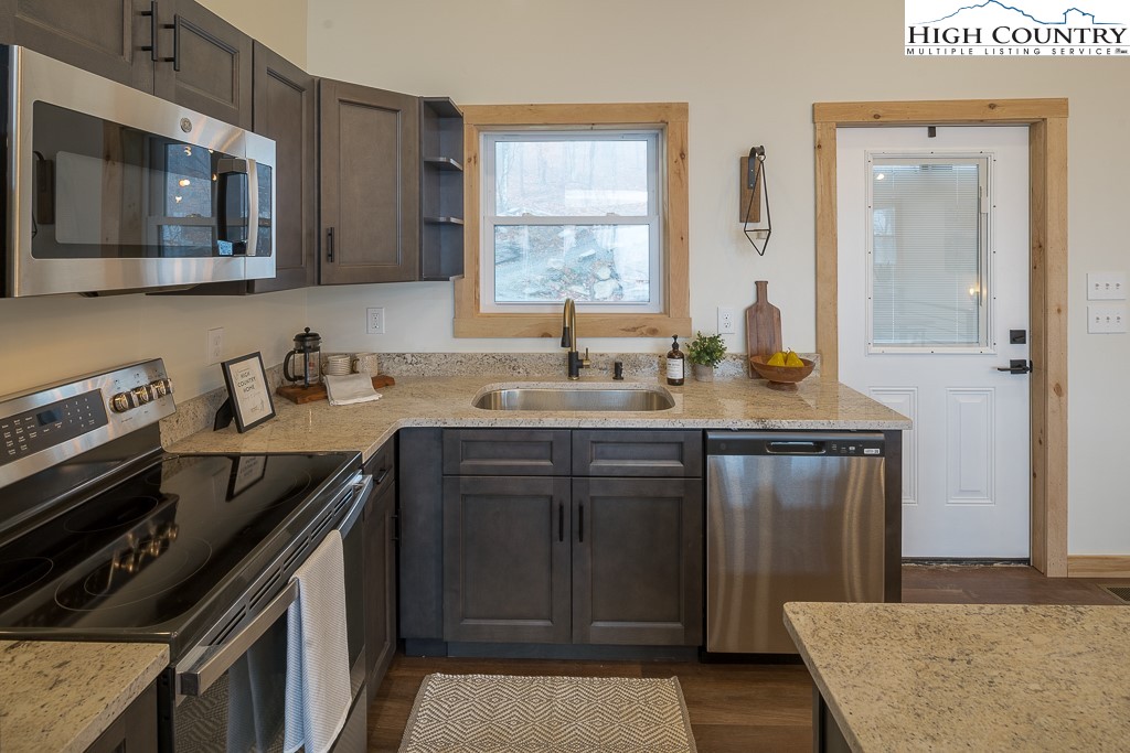 232 Wild Daisy Lane Beech Mountain, NC 28604 - Photo 15 of 49 a kitchen with a sink stove and microwave