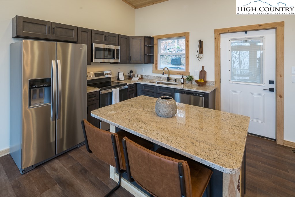232 Wild Daisy Lane Beech Mountain, NC 28604 - Photo 17 of 49 a kitchen with stainless steel appliances granite countertop a refrigerator a stove and a sink with wooden floor