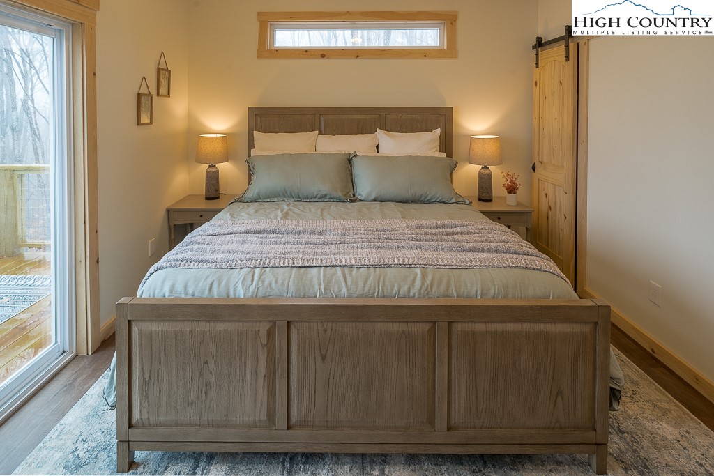 232 Wild Daisy Lane Beech Mountain, NC 28604 - Photo 21 of 49 a bedroom with a bed and wooden floor
