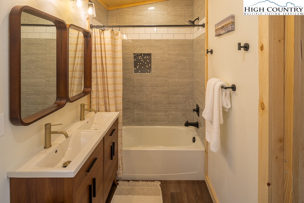 232 Wild Daisy Lane Beech Mountain, NC 28604 - Photo 22 of 49 a bathroom with a tub sink shower and mirror