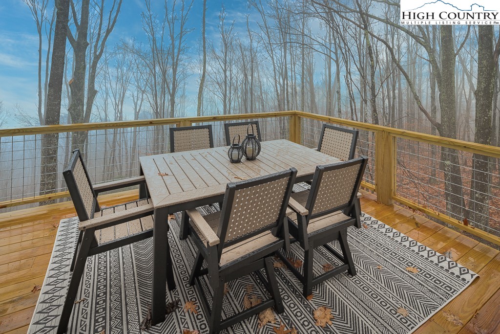 232 Wild Daisy Lane Beech Mountain, NC 28604 - Photo 23 of 49 a view of a chairs and table on the deck