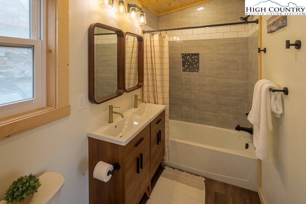 232 Wild Daisy Lane Beech Mountain, NC 28604 - Photo 33 of 49 a bathroom with a sink mirror toilet and bathtub