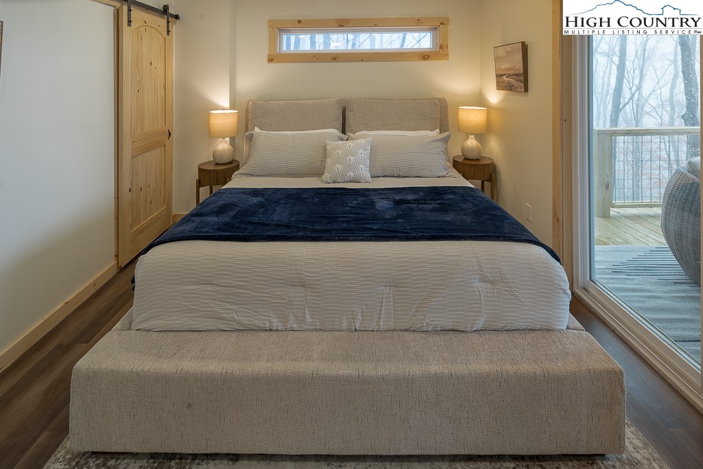 232 Wild Daisy Lane Beech Mountain, NC 28604 - Photo 37 of 49 a spacious bedroom with a bed and wooden floor