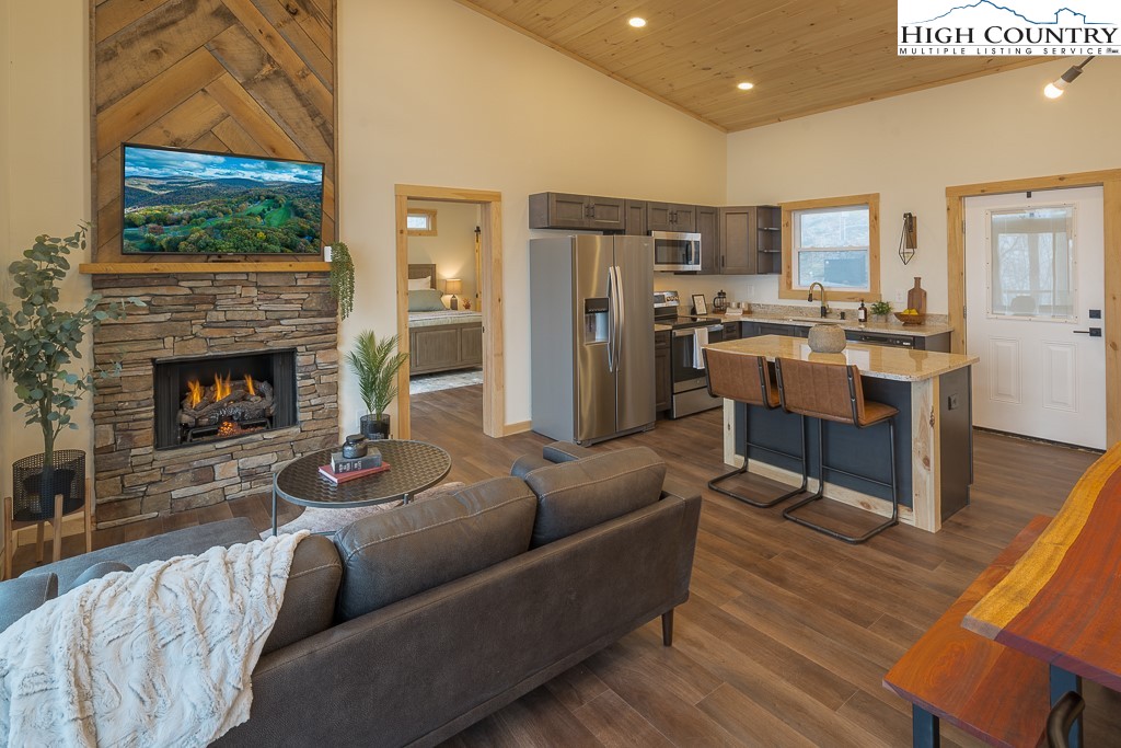 232 Wild Daisy Lane Beech Mountain, NC 28604 - Photo 5 of 49 a living room with furniture a flat screen tv and a fireplace