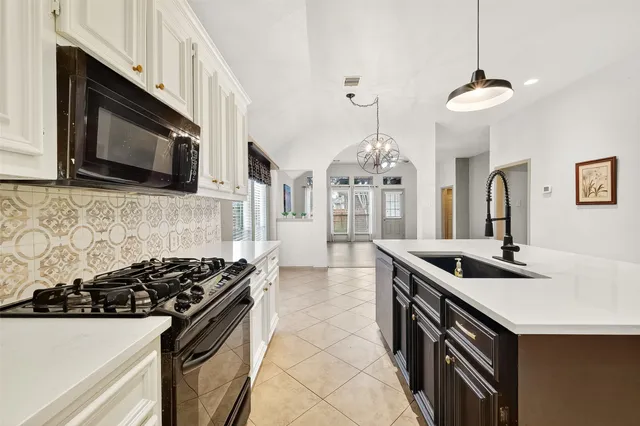 a kitchen with stainless steel appliances granite countertop a sink stove and microwave