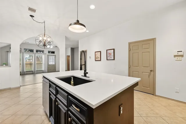 a kitchen that has a sink a stove and a table with chairs