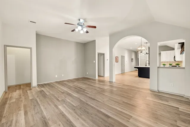 a view of an empty room and kitchen view