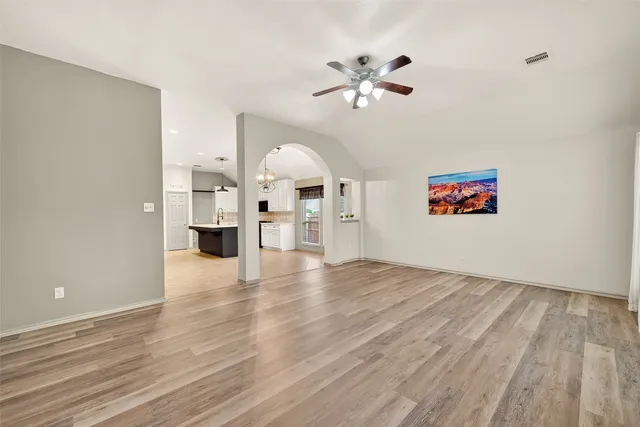 a view of an empty room and a kitchen