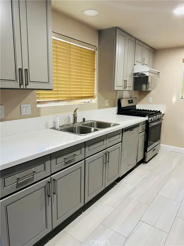 a kitchen with stainless steel appliances granite countertop a sink and a stove