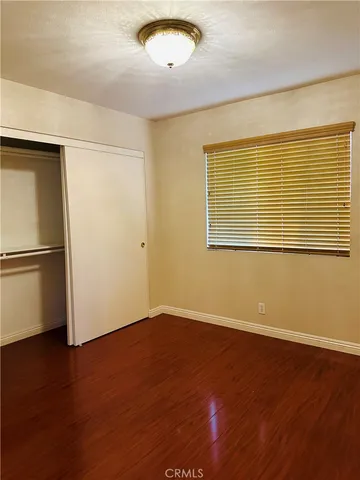 an empty room with wooden floor and a window