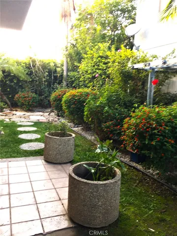 a view of a garden with a dining table and chairs