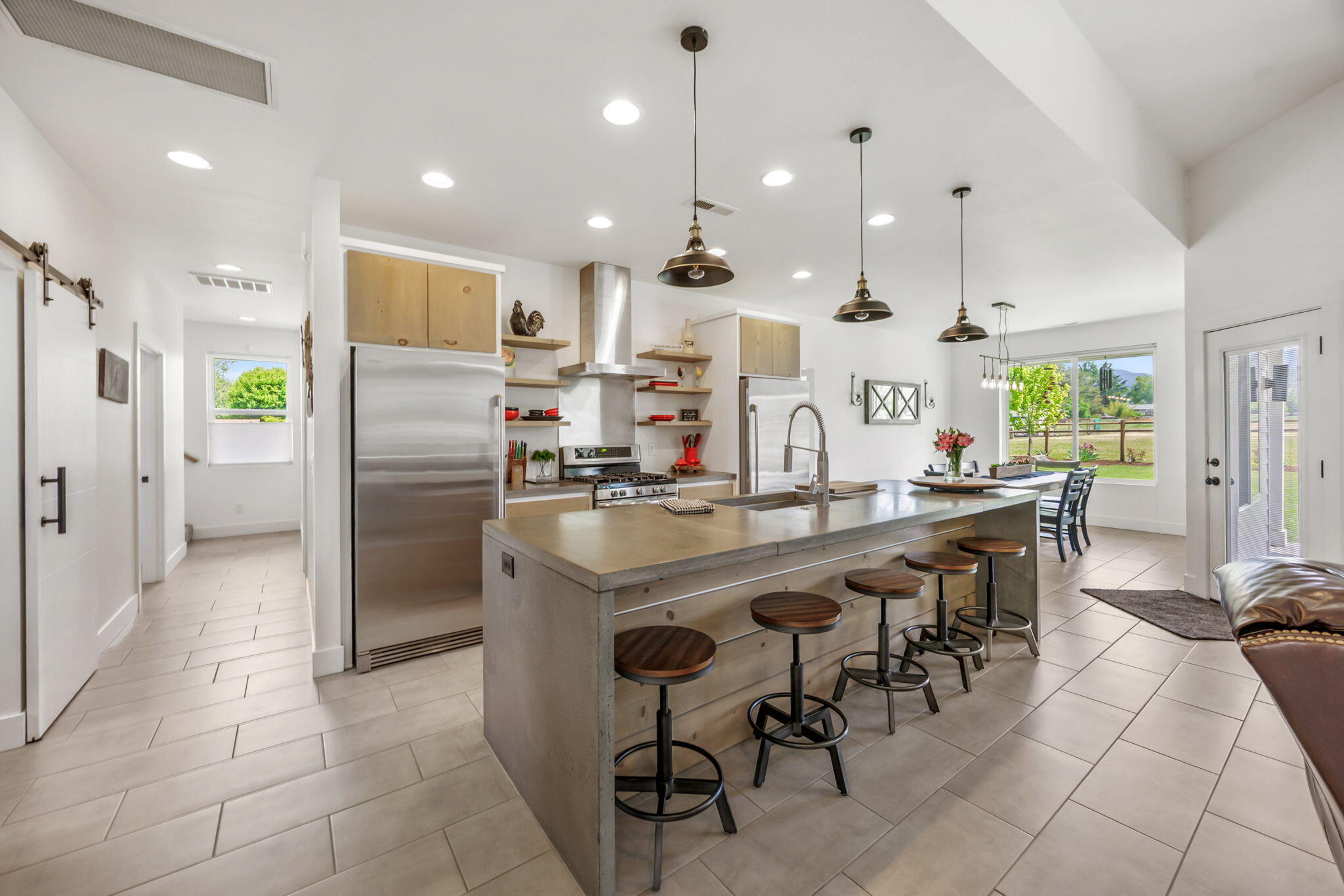 1827 Houston Road Medford, OR 97501 - Photo 36 of 70 a kitchen with stainless steel appliances kitchen island granite countertop a table chairs and a refrigerator