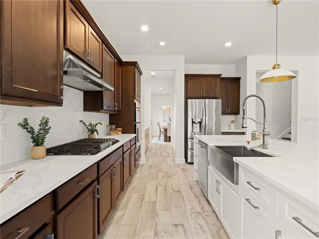 a kitchen with a sink stove top oven and refrigerator