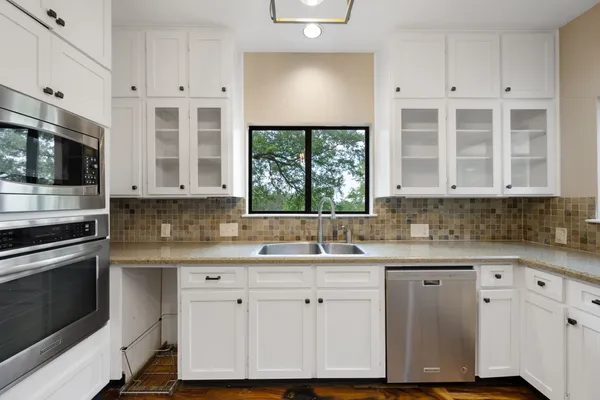 a kitchen with a refrigerator and white cabinets
