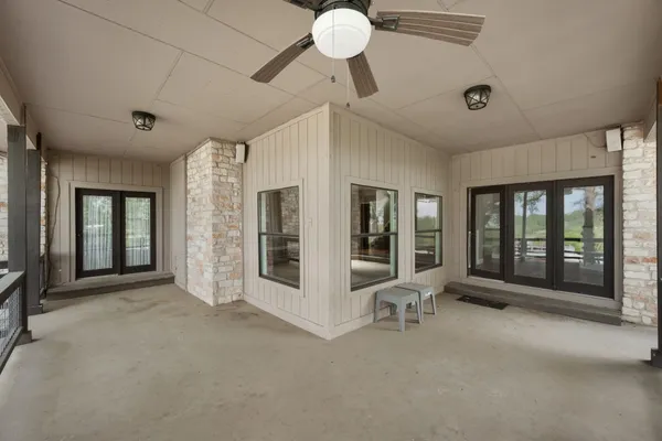 a view of a balcony with wooden floor and large trees