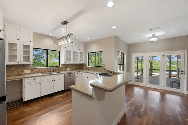 a kitchen with stainless steel appliances granite countertop a sink a stove a microwave and cabinets