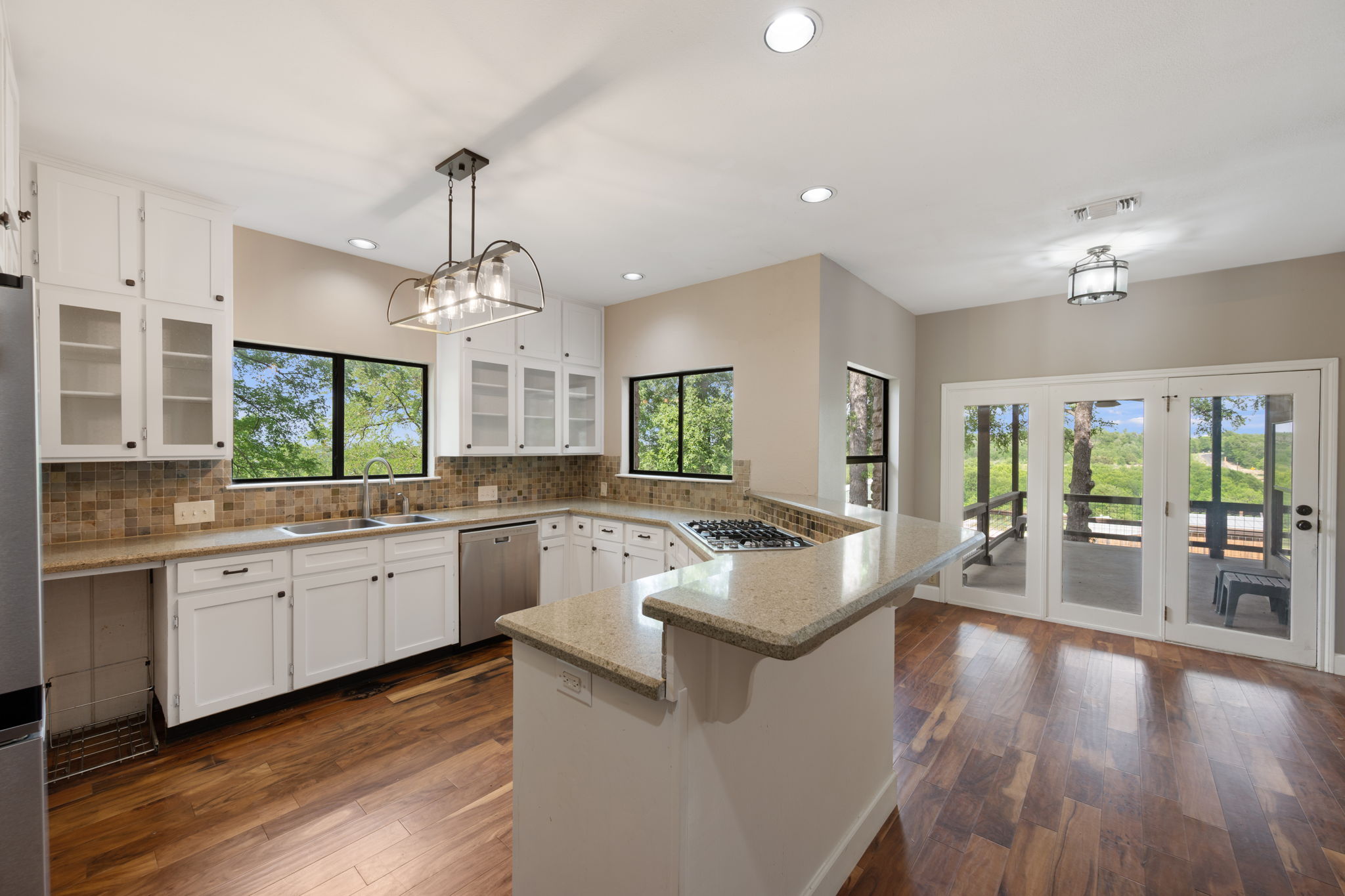 330 County Road 166 Georgetown, TX 78626 - Photo 10 of 40 a large kitchen with granite countertop a large center island a sink dishwasher a stove and a dining table with wooden floor