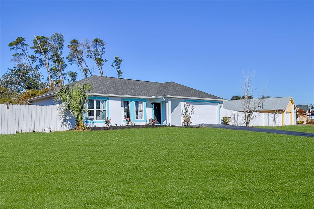 a front view of a house with a garden and yard