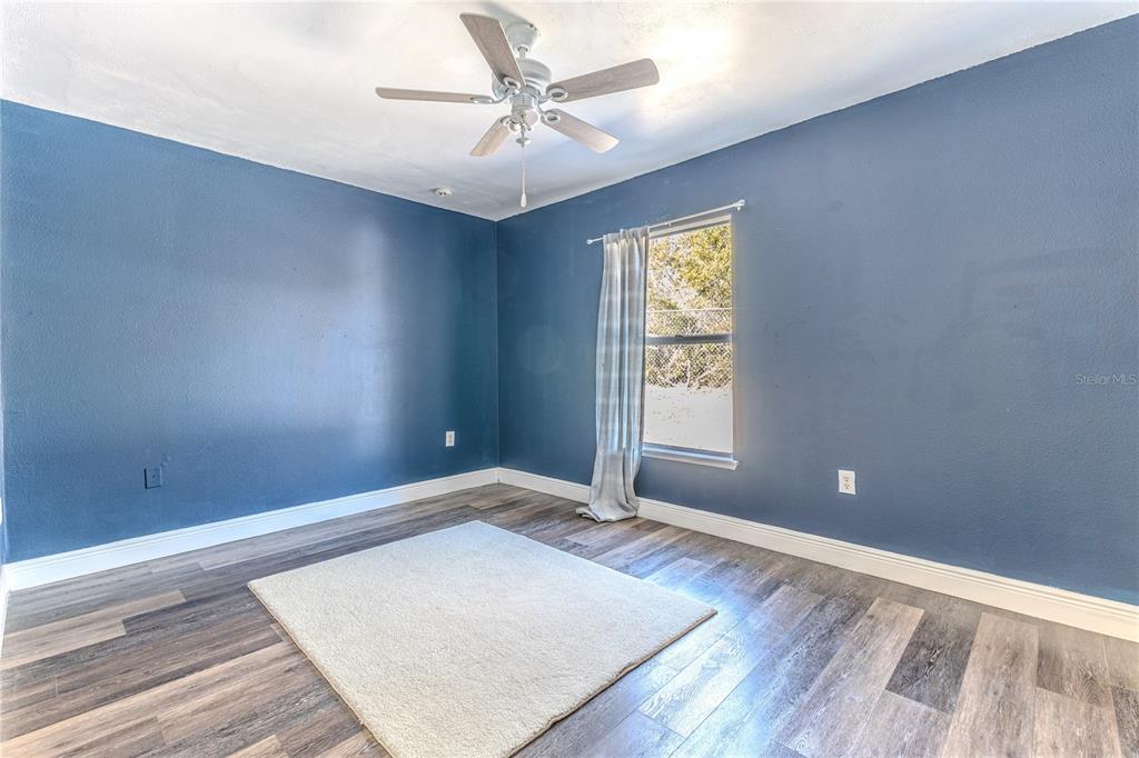 5437 Freeport Drive Spring Hill, FL 34606 - Photo 17 of 34 an empty room with wooden floor and windows