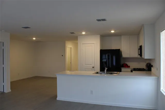 a view of a kitchen with a sink and a refrigerator