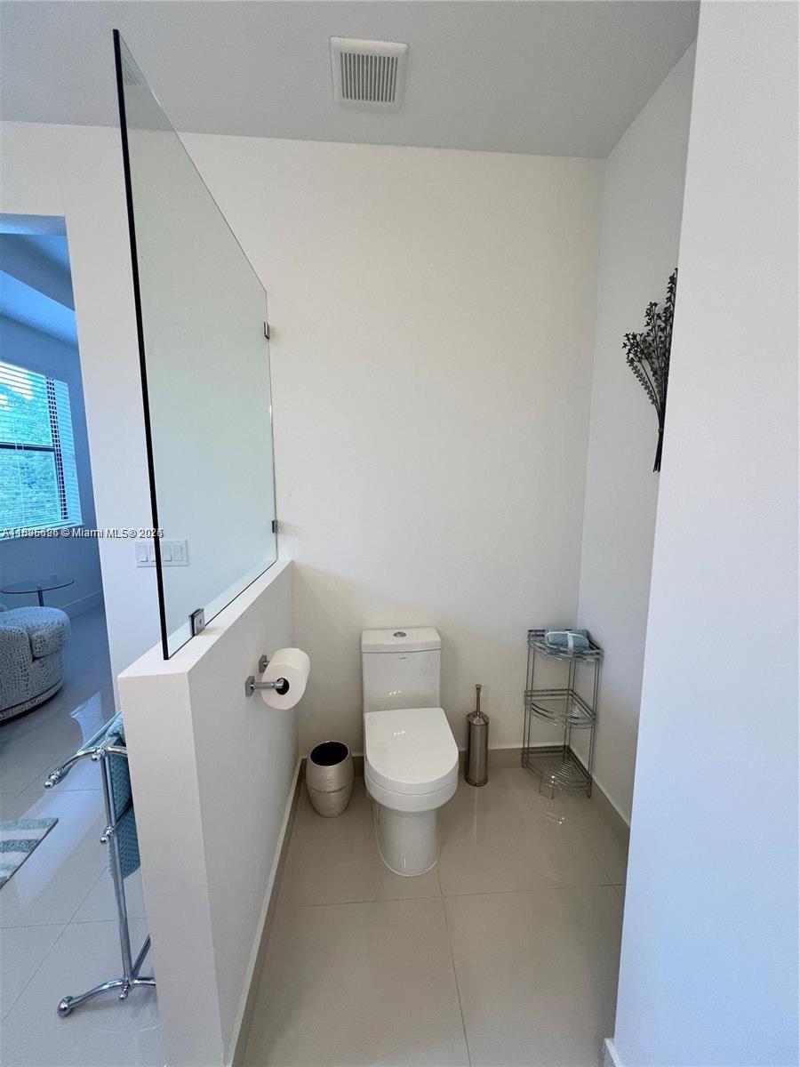 Kendall Miami, FL 33186 - Photo 20 of 30 a white toilet sitting next to a white sink and vanity