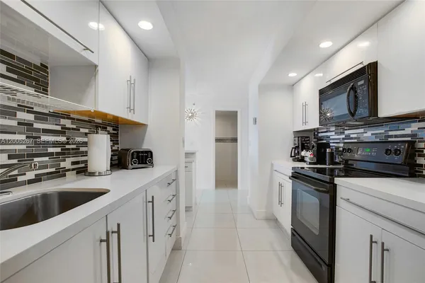 a kitchen with stainless steel appliances granite countertop a sink stove oven and refrigerator