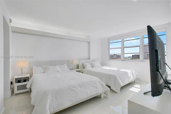 a bedroom with two beds and a flat tv screen on a dresser